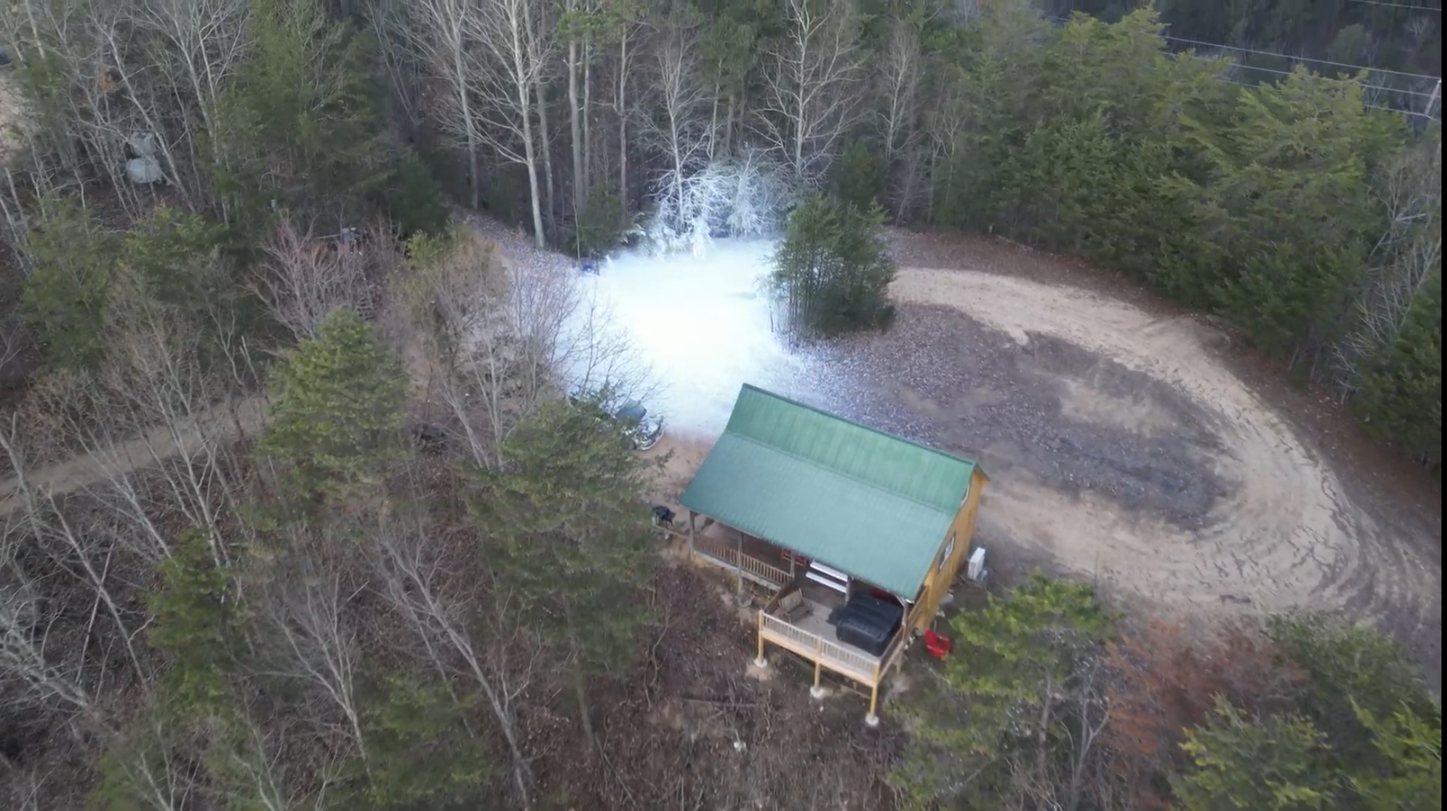 Drone view of snowy cabin property